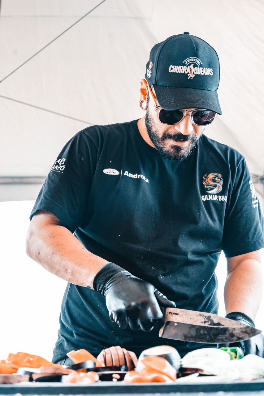 Gilmar cortando carne em ação durante evento